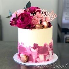 there is a pink and white cake with flowers on it