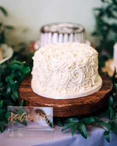 a white cake sitting on top of a wooden platter