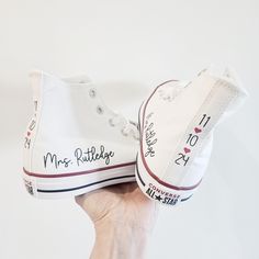 someone is holding up their wedding converse shoes