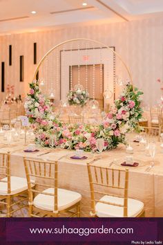 the tables are set up for a wedding reception with floral centerpieces and candles