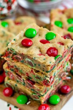 christmas cookie bars stacked on top of each other with green and red candies around them