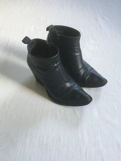 vintage John Fluevog ankle boots made in Portugal Entrance Room 406, discontinued style swordfish inspired toe bump asymmetrical front seam inside zipper black leather man made sole style # 1284025 lived in age worn quality, still have life left-see photos scuffs, marks, fade, fray label size women's 6 1/2 measures, insole-9 1/4" toe to heel sole-9" width-3 7/8" heel-3" total height-6" shaft top circumference-10" total Entrance Room, Womens Booties, John Fluevog, Leather Man, Ankle Boots Black, Black Leather Boots, Heeled Ankle Boots, Black Ankle Boots, Boots Black