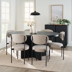 a dining room table with chairs and a vase on it