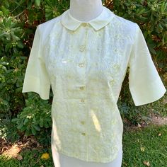 This is a super pretty blouse made by Jean Taylor from the 1950s The material is Shikibo Tetoron  Lightweight and breathable! Tag size is a small This is single stitch and in perfect condition, no flaws, like new, preserved very well! I adore the floral embroidered pattern on it It buttons for closure and has a cute collar Measurements as follows: Pit to pit laying flat is 18.5" inches Width at bottom is 18.5" inches laying flat  Length is 22" inches  I ship priority mail with tracking! Thanks f Retro Short Sleeve Top With Floral Embroidery, Fitted Shirt With Floral Embroidery For Daywear, Vintage Floral Embroidered Short Sleeve Shirt, Fitted 1950s Style Summer Tops, Fitted 1950s Summer Tops, Fitted Yellow Vintage Blouse, Fitted Blouse With Peter Pan Collar And Embroidery, Fitted Embroidered Blouse With Peter Pan Collar, Vintage Blouse With Floral Embroidery For Daywear