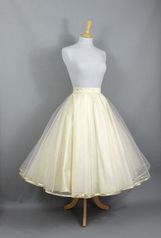 "This show stopping bridal skirt is made from a layer of Champagne Silk Dupion and a layer of ivory tulle hemmed in Gold trim. The tulle layer is a double circle which means lots and lots of volume! Wear with a 'Swing' petticoat for extra swish on the dance floor (or seen in the last photo without a petticoat underneath) and choose your length to create a unique outfit for your special day. Off-the-peg in a size  UK 16 (US 14/EU 44). It has been made to fit a waist measurement of 33-34\" (83-87c Gold Champagne Bridesmaid Skirt, Double Citcle Skirt, Champagne Wedding Skirt, Wedding Tea Length Dress With Tulle Skirt, Elegant White Skirt For Debutante Ball, White Tulle Skirt For Wedding, Elegant Organza Petticoat With Tulle Skirt, Elegant Organza Wedding Petticoat, Elegant Wedding Organza Petticoat