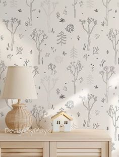 the wallpaper is white and has trees on it, as well as a lamp