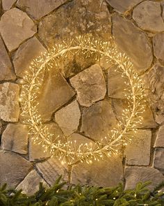 a lighted wreath on a stone wall