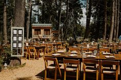 an outdoor dining area in the woods with tables and chairs set up for people to eat