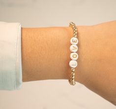 These word bracelets are ultra customizable. They feature painted resin letters on a gold-filled stretch bracelet. Choose your letter colorway, and create any name or word you could imagine! Our stretch gold-filled bracelets are made with love in New York City. They are made with high-quality gold-filled beads that do not tarnish or turn colo The lettering on our resin beads is painted on and may fade with time. Avoid excessive contact with water to increase its longevity! Custom sizing is avail Custom Text Gold Beaded Bracelets As Gift, Custom Text Gold Beaded Bracelet Gift, Custom Text Gold Beaded Bracelets For Gifts, Custom Text Beaded Gold Bracelets For Gift, Meaningful Adjustable Gold Stretch Bracelet, Adjustable Gold Stretch Bracelet With Meaningful Style, Meaningful Gold Bracelets With Round Beads, Meaningful Gold Name Bracelet With Letter Beads, Trendy Jewelry With Letter Print On Round Beads