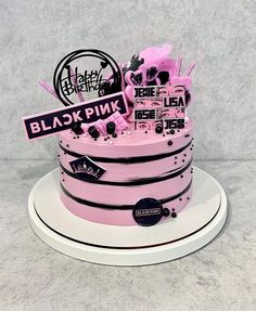 a pink cake with black and white decorations