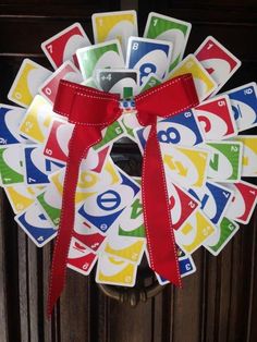 a wreath made out of cards with a red bow on it's front door