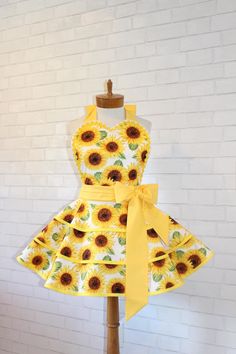 a dress with sunflowers on it and a yellow bow