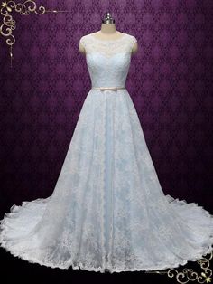 a white wedding dress on display in front of a purple wall