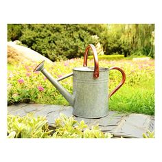 a watering can with a handle on the ground