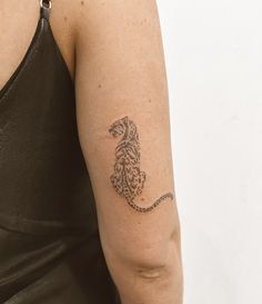 a woman's arm with a tattoo on her left arm and a chain attached to it