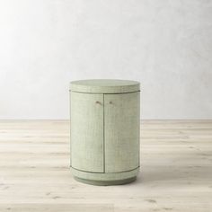 a round cabinet sitting on top of a hard wood floor next to a white wall