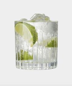 a glass filled with ice and lime slices