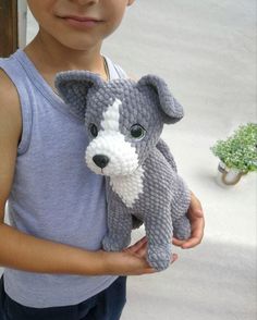 a young boy holding a stuffed animal in his hands