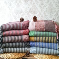 a stack of folded towels with pine cones on the top and one in the middle