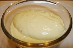 a glass bowl filled with cream on top of a table