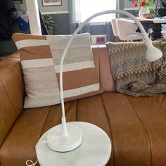 a table lamp sitting on top of a brown couch