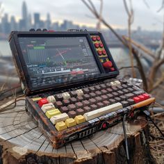 an open laptop computer sitting on top of a tree stump