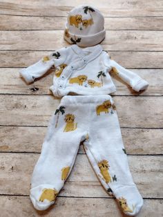 OOAK baby doll boy's 3 piece footed pajamas set, outfit, clothes to fit a 7" OOAK baby, reborn or silicone doll.  The pajamas are white with little lions and palm trees.   The pajama top has 4 working snaps down the front and the pants have an elastic waist.  All of my clothes are made from brand new baby outfits or fabrics and handmade by me. Pajama top measures 2 3/4" from back of neck to bottom hem.  Sleeves are 2 1/2" from shoulder to wrist.  There are 4 working snaps across the front.  The footed pajamas pants have an elastic waist and measure 3 5/8" from waist to ankle.  the pajama feet measure 1 1/8" across sole.  The hat is 5 1/2" in diameter. I do combine shipping when purchasing more than one item. Boys Footed Pajamas, Pajamas Outfit, Pajama Outfit, Baby Reborn, Footed Pajamas, Silicone Dolls, My Clothes, Baby Outfits, Pajamas Set