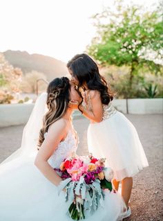 two brides kissing each other in the desert