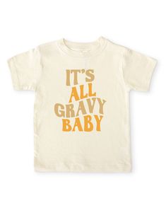 A fun, retro kids shirt for fall and Thanksgiving. Features an alternating tan and mustard yellow "it's all gravy baby" retro wavy text on our cozy gender neutral toddler crew neck tee. Made from buttery-soft airlume cotton that provides all day comfort, breathability and flexibility for all activity levels. ☑ 100% combed ringspun airlume cotton☑ Buttery-soft, light-weight & breathable material☑ Unisex fitted short sleeve crew neck ☑ Flatlock seams to eliminate friction☑ Double-needle ribbed bin Cream Graphic T-shirt For Fall, Cream Graphic Print T-shirt For Fall, Cream Short Sleeve T-shirt For Fall, Orange Graphic Tee With Graphic Print, Mustard Cotton T-shirt With Graphic Print, Mustard Graphic Print Cotton T-shirt, Toddler T Shirt Ideas, Kids Vinyl Shirt Ideas, Toddler Shirt Ideas