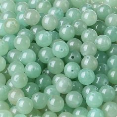 many green beads are shown together in this close up photo, with the beading visible