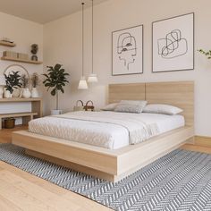 a bed sitting in the middle of a bedroom next to two pictures on the wall