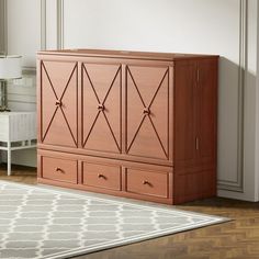 a large wooden cabinet sitting on top of a hard wood floor next to a white rug