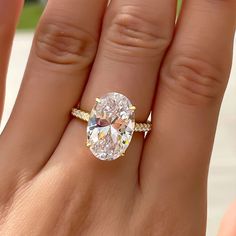 a woman's hand with a ring on it and an oval shaped diamond in the middle