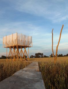 a tall wooden structure sitting in the middle of a field