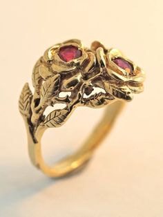 Two detailed roses make up this elegant ring, their stems entwining and forming the band. The ring is cast in solid 14K gold and two 3 mm rubies are set in the center of each rose. Indulge yourself or someone special in this sparkling bouquet. We will contact you to let you know if we have your chosen ring size in stock or when to expect shipment. All Marty Magic Jewelry is packaged in a beautiful ring box embossed with the gold foil Marty Magic dragon logo. Perfect for any occasion! Designed in Vintage 14k Gold Flower Ring, Vintage Rose Gold 14k Gold Flower Ring, Vintage 14k Rose Gold Flower Ring, Formal Yellow Gold Flower Ring With Rose Design, Vintage 14k Gold Flower Ring For Anniversary, Vintage Rose Flower Ring For Wedding, Vintage Rose Gold Flower Ring For Formal Occasions, Vintage Rose Gold Flower Ring For Formal Events, Vintage Rose Design Flower Ring For Wedding