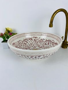 a bowl shaped sink sitting next to a faucet