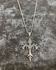 Ignite your style with our Flame Cross Gothic necklace, a captivating blend of dark allure and fiery elegance. This eye-catching piece features a striking silver chain that holds a bold cross pendant, intricately detailed with flame motifs that evoke both intensity and passion. The pendant's dark, burnished finish is contrasted by the gleaming silver highlights, creating a dramatic effect that catches the eye from every angle. Designed for those who embrace gothic sophistication with a touch of Necklace Grunge, Cross Gothic, Grunge Necklace, Goth Necklace, Silver Highlights, Gothic Necklace, Cross Pendant Necklace, Gothic Jewelry, Necklace Vintage