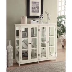 a white china cabinet with glass doors in a living room