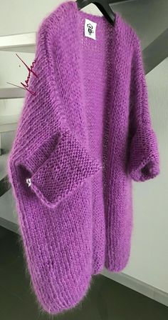 a purple sweater hanging up on a hanger