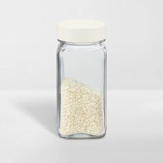 a glass jar filled with rice on top of a white table