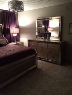 a bedroom scene complete with a bed, dresser and mirror on the side table in front of two lamps