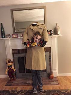 a man in a trench coat is holding up a fake dummy with flowers on it