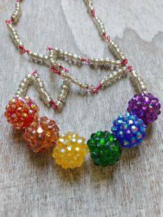 Fun rainbow style necklace with Cluster Faceted multi color acrylic beads. Accented with small glass beads on hot pink metal wire. Lobster clasp. Adjustable Rainbow Crystal Necklace With Faceted Beads, Rainbow Beaded Necklace For Party, Rainbow Faceted Round Bead Necklaces, Rainbow Jewelry With Beaded Round Beads, Rainbow Faceted Beads Necklace For Gift, Rainbow Beaded Chain Jewelry With Round Beads, Rainbow Jewelry With Round Beaded Chain, Rainbow Round Bead Adjustable Necklace, Rainbow Necklaces With Spacer Beads For Jewelry Making