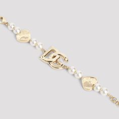 Dolce & Gabbana Gold Bracelet. Pure gold-tone brass bracelet, front signature DG logo, tonal hearts details, white plastic pearl details, back lobster adjustable fastening. Metallic Bracelet, Dolce Gabbana Jewelry, Dg Logo, Pearl Details, Brass Bracelet, Pure Gold, Metal Bracelets, Handbag Accessories, Base Colour