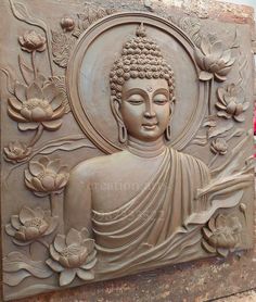 a buddha statue sitting on top of a stone wall