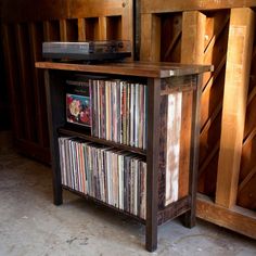 an old record player sits on top of a wooden shelf filled with records and cds