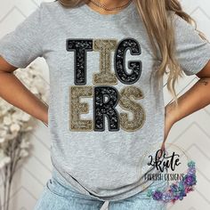 Pick yourself up one of these fun and spirit-filled Tigers spirit shirts. This shirt is sure to impress your friends and make them want one for themselves.  It's a very soft shirt in an athletic heather (gray) color. The shirt is made of 95% polyester but has a cotton feel.  This shirt is a digital print of sequins. These are not real sequins. There is no 3D feeling to the shirt. It is printed directly onto the shirt.  To get the best wear from your shirt make sure to  1. Wash in cold water 2. Tumble dry low 3. Do not iron on design area 4. Do not use fabric softener unisex sizing. School Spirit T-shirt For Cheerleading In Fall, Game Day Team Spirit T-shirt With Glitter Print, Team Spirit T-shirt For Game Day With Glitter Print, Short Sleeve Tops With Glitter Print For Game Day, Casual Fall T-shirt With Sequins, Game Day Glitter Print Crew Neck T-shirt, Casual Sequined T-shirt For Fall, Casual Game Day T-shirt With Glitter Print, Sporty Cheerleading T-shirt For Fall