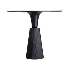 a black table sitting on top of a white floor next to a wooden pedestal with an oval