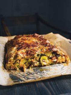 a piece of quiche sitting on top of a wooden table