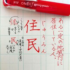 an ink pen with chinese writing on it next to a piece of paper that has been written in two different languages